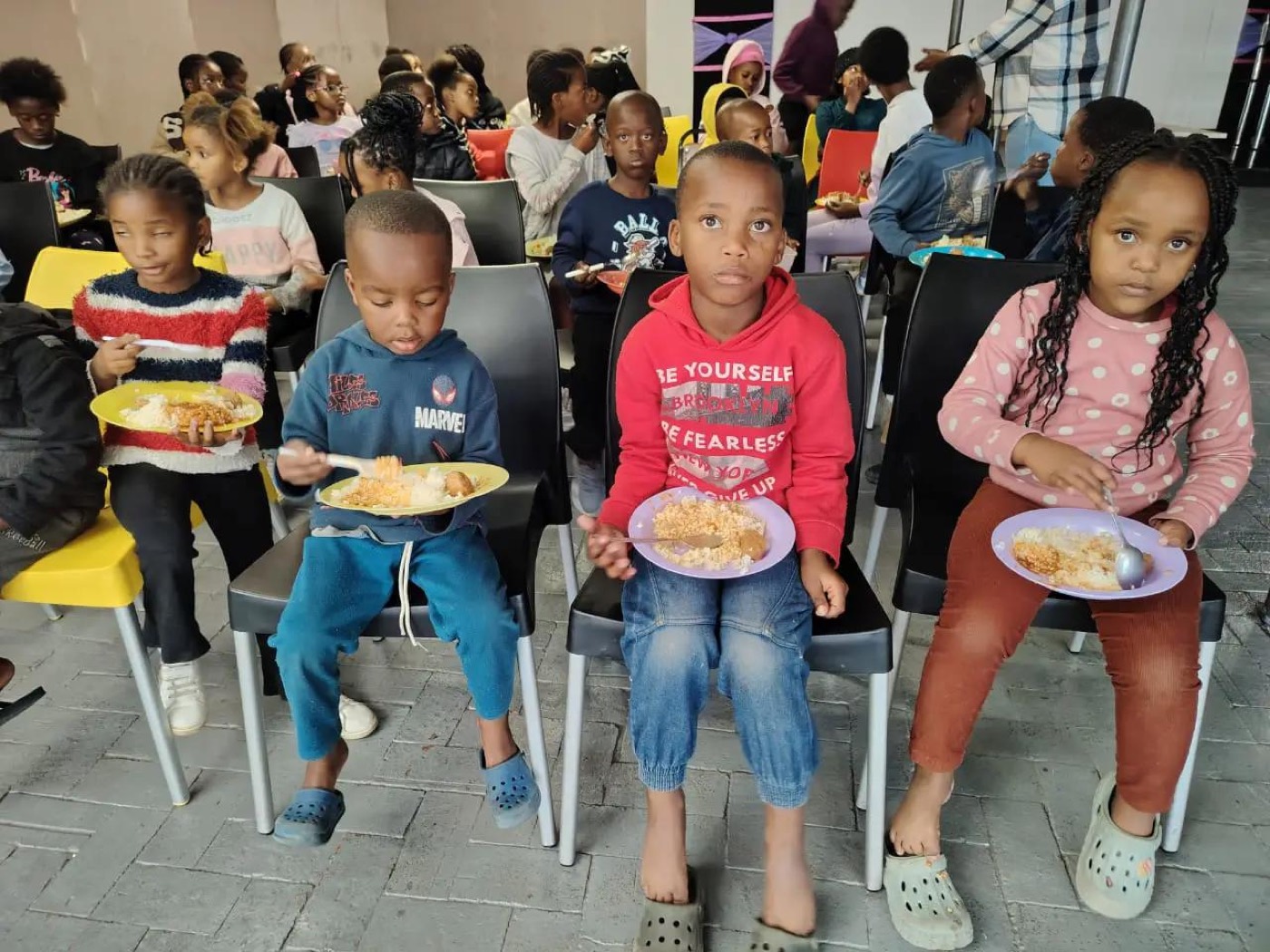 Children seated and enjoying a hot plate of food